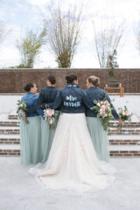 Bride with Bridesmaids Wearing Signature Mrs. Jean Jacket | Carrie Wildes Photography