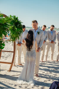 St. Pete Beach Bride and Groom Exchange Vow Portrait, Tropical Inspired Wooden Circle Arch with Greenery Flora | Florida Beach Wedding Ceremony