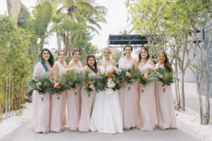Tropical Pink and Green Wedding, Bride with Bridesmaids in Mix and Match Blush Pink Dresses Holding Tropical Floral Bouquets | St. Pete Waterfront Wedding Venue Hotel Zamora | Tampa Bay Wedding Hair and Makeup Savannah Olivia Beauty | Lemon Drops Floral