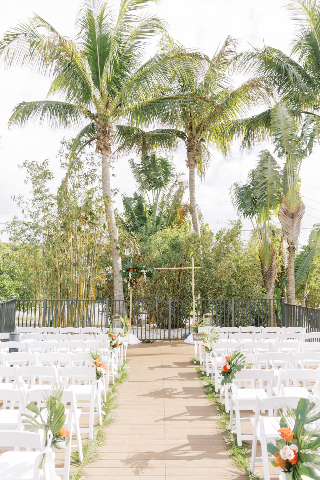 Tropical Pink and Green Outdoor Courtyard Wedding Ceremony Decor, Monstera Palm Leaves with Orange and Pink Flowers, Bamboo Arch | Tampa Bay Wedding Planner Coastal Coordinating | St. Pete Wedding Venue Hotel Zamora