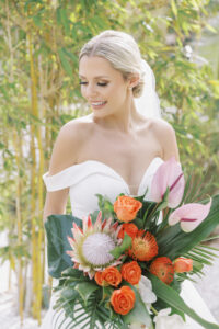 Florida Bride Wedding Portrait Holding Tropical Monstera and Palm Frond Leaves, Orange Roses, King Protea, Pincushion Protea, Pink Anthurium Floral Bouquet | Lemon Drops Floral