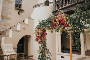 Florida Outdoor Jewish Wedding Chuppah | Wooden Ceremony Chairs and Wooden Wedding Arch with Orange and Pink Florals at Estate Wedding Ceremony in South Florida | Sarasota Wedding Planner MDP Events