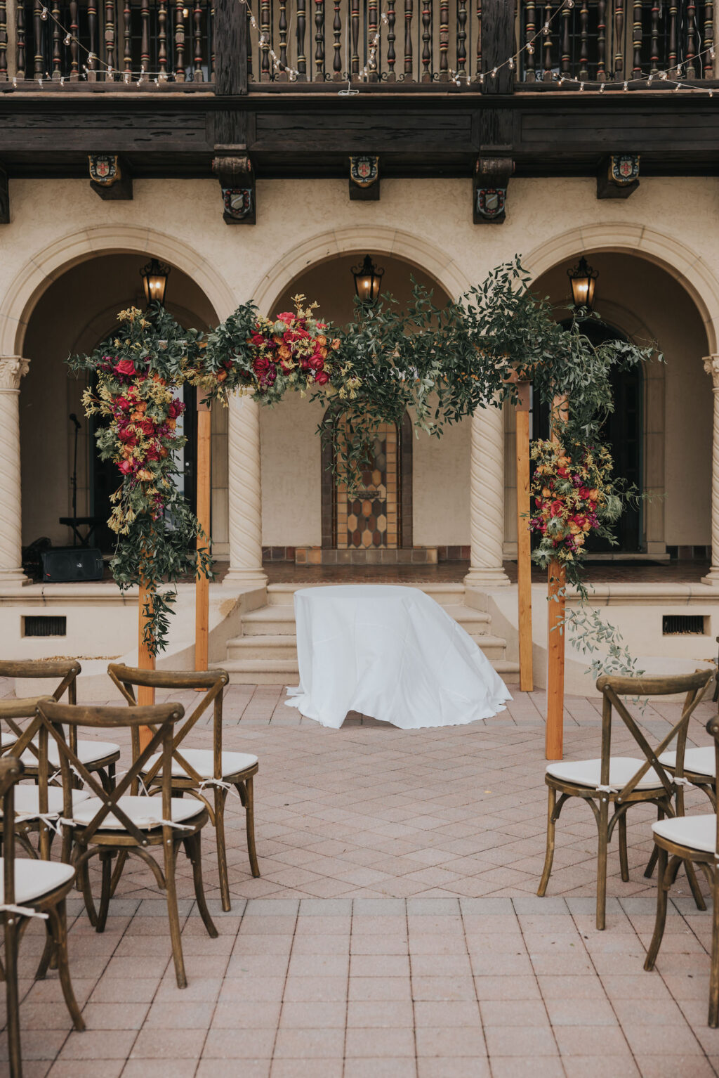 Florida Outdoor Jewish Wedding Chuppah | Wooden Ceremony Chairs and Wooden Wedding Arch with Orange and Pink Florals at Estate Wedding Ceremony in South Florida | Sarasota Wedding Planner MDP Events