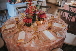 Moody Tablescapes with Clear Plating with Gold Trim and Pink and Orange Floral Centerpieces | Candle and Fruit Wedding Decor | MDP Events
