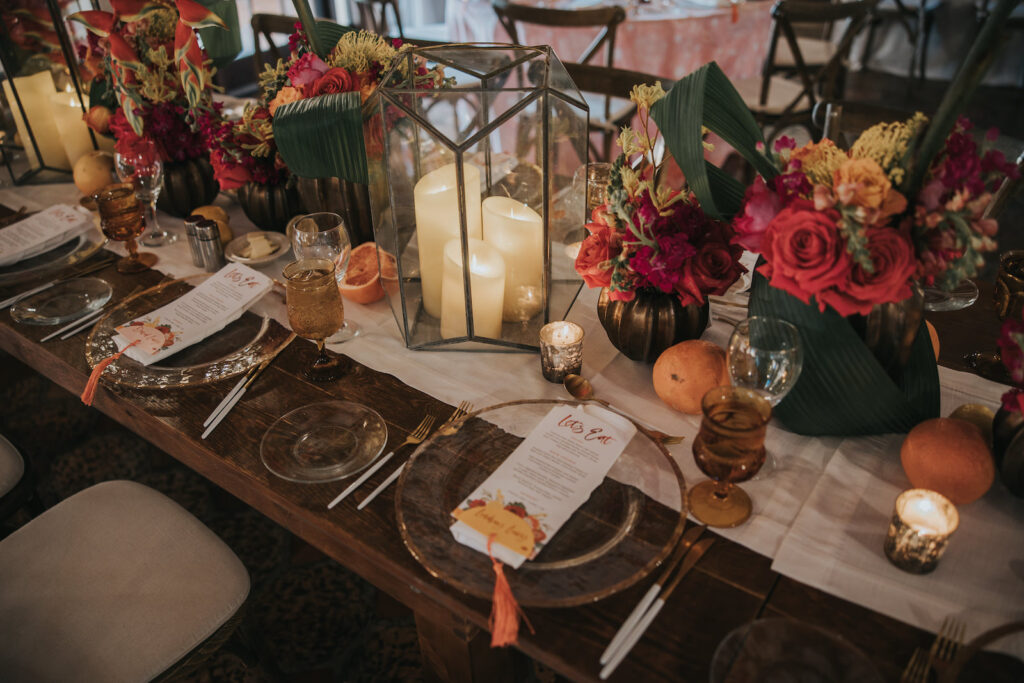 Moody Tablescapes with Clear Plating with Gold Trim and Pink and Orange Floral Centerpieces | Candle and Fruit Wedding Decor | MDP Events