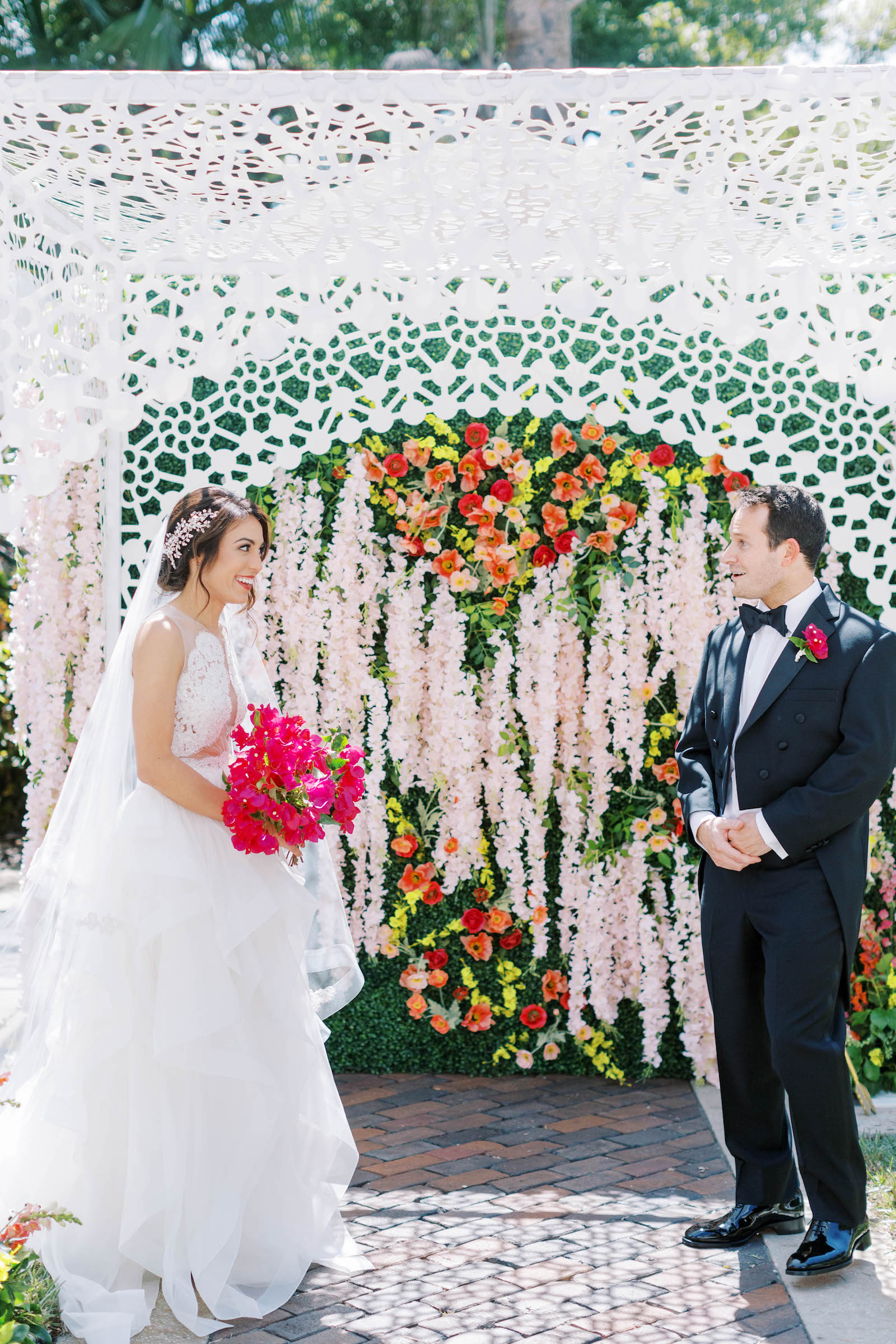 Bride and Groom First Look Wedding Portrait | Floral Archway with Pink, Orange, and Yellow Flowers and Greenery Detailing | Wedding Planner St. Petersburg Parties a la Carte