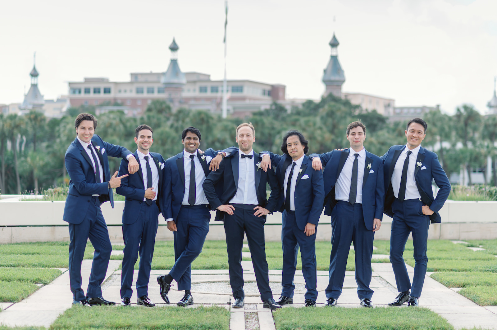 White and Green Modern Minimalist Tropical Wedding, Groom and Groomsmen Wearing Navy Blue Suits Outside The University of Tampa