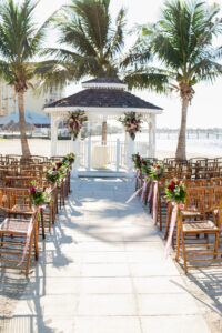 Dusty Rose and Mauve Waterfront Wedding Ceremony Decor, Wooden Bamboo Chairs, Tropical Floral Arrangements, Gazebo | Tampa Bay Wedding Photographer Carrie Wildes Photography | St. Pete Wedding Venue Isla Del Sol Yacht and Country Club | Wedding Chair Rentals A Chair Affair | Wedding Planner Perfecting the Plan