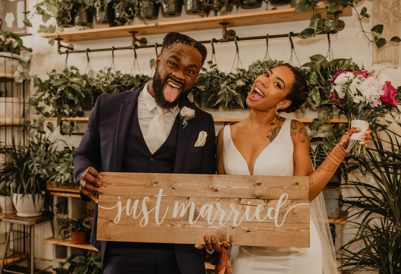 Intimate Elopement Wedding Ceremony, Bride and Groom Holding Wooden Just Married Sign at Unique Plant Shop Wedding Venue Wild Roots | Tampa Bay Wedding Planner Elope Tampa Bay