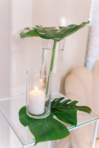 White and Green Modern Minimalist Tropical Wedding Ceremony Decor, Hurricane Glass Vase with Candle, Monstera Palm Leaves, Glass Side Table | Tampa Bay Wedding Planner Taylored Affairs