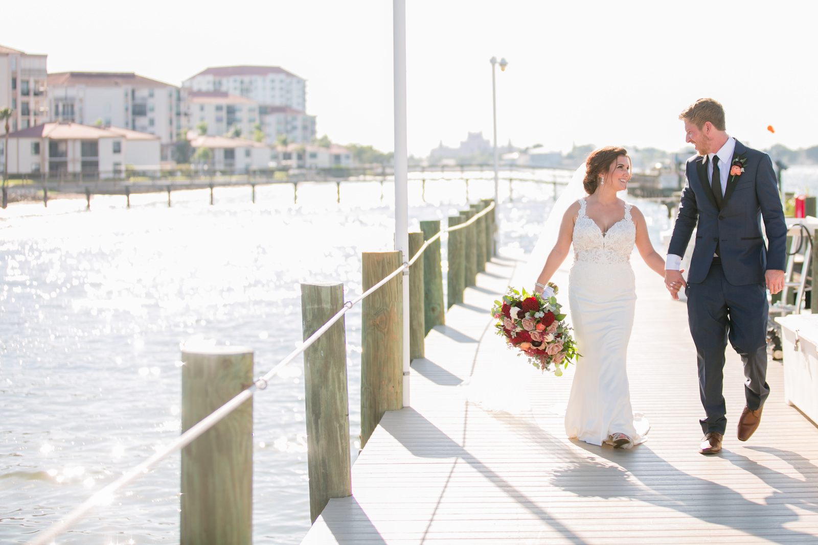 Bride and Groom Walking on Boat Dock Wedding Portrait | Tampa Bay Wedding Photographer Carrie Wildes Photography | Wedding Florist Iza’s Flowers | St. Pete Wedding Venue Isla Del Sol Yacht and Country Club