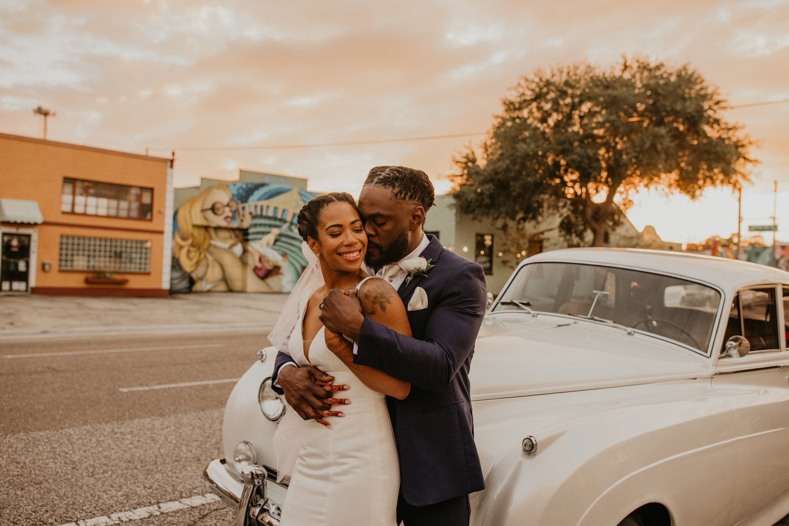 Intimate Elopement Wedding, Bride and Groom Standing Outside Vintage White Get Away Car