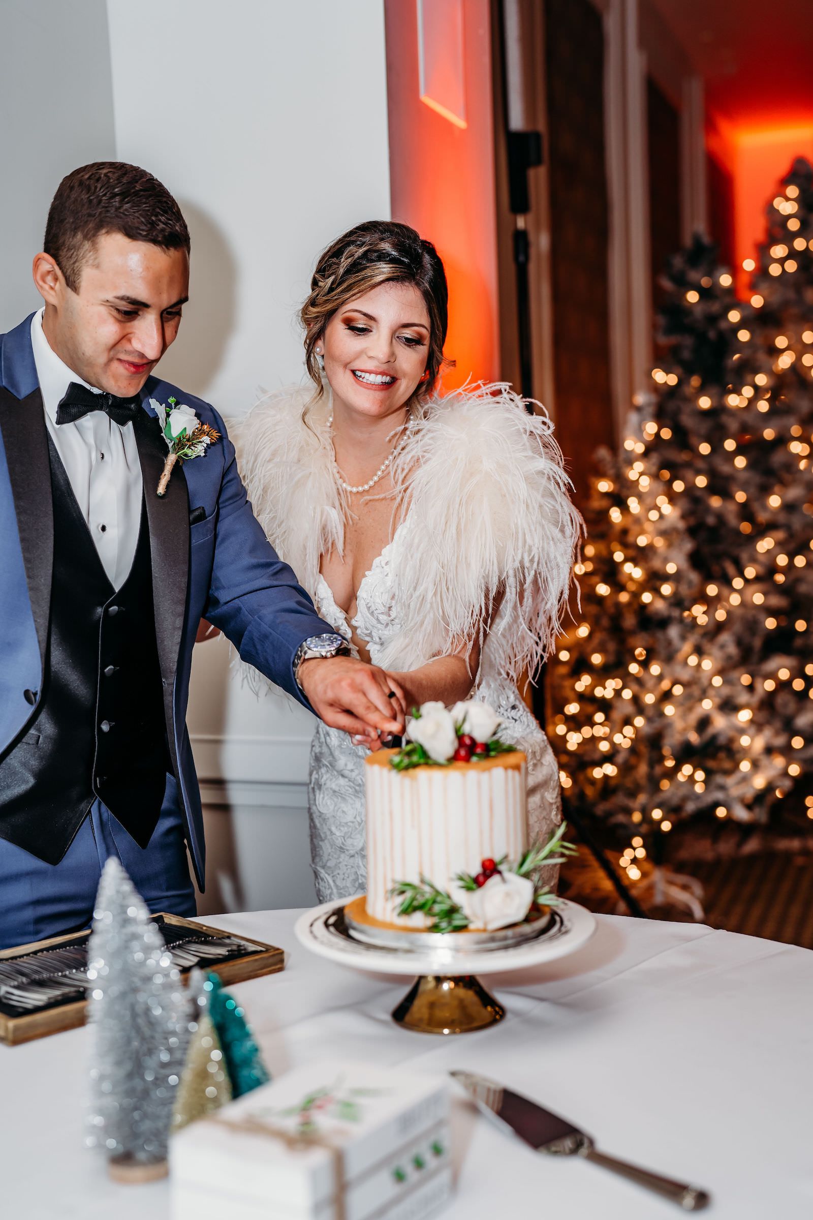 Christmas Wedding, Bride Wearing Feather Shall and Groom Cutting One Tier Wedding Cake