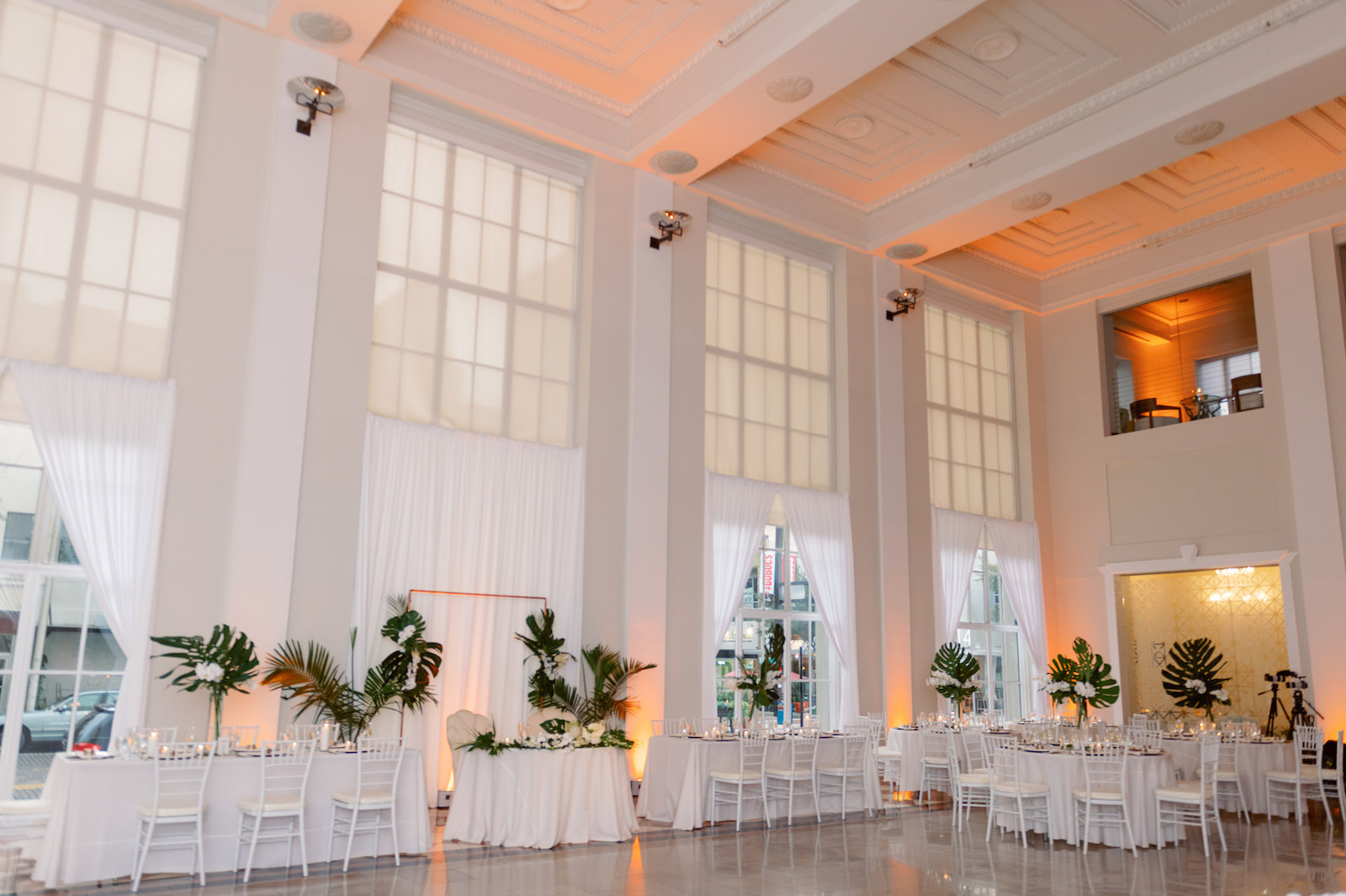 White and Green Modern Minimalist Tropical Wedding Reception Decor, White Chiavari Chairs, Monstera and Palm Fronds with White Flowers Centerpieces | Tampa Bay Wedding Planner Taylored Affairs | Downtown Tampa Wedding Venue The Vault