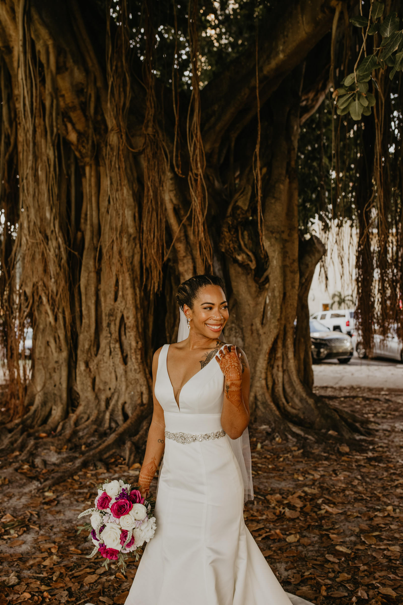 Intimate Elopement Wedding, Bride with Henna Tattoo Wearing Plunging V Neckline Fitted Wedding Dress with Rhinestone Crystal Belt Holding White and Pink Floral Bouquet | Tampa Bay Wedding Planner Elope Tampa Bay
