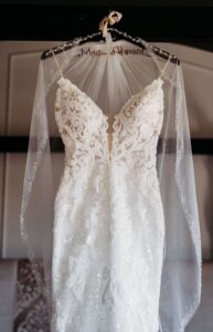 Lace and Illusion Fitted Wedding Dress with Veil Hanging on Bed