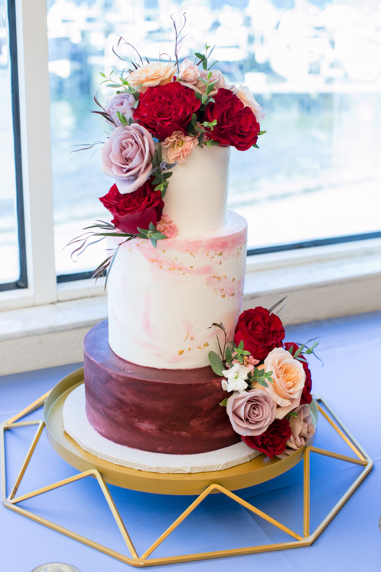 Three Tier Wedding Burgundy Red and White Wedding Cake, Real Mauve, Blush Pink and Red Roses Cake Topper on Gold Geometric Stand | Tampa Bay Wedding Photographer Carrie Wildes Photography | Wedding Florist Iza’s Flowers