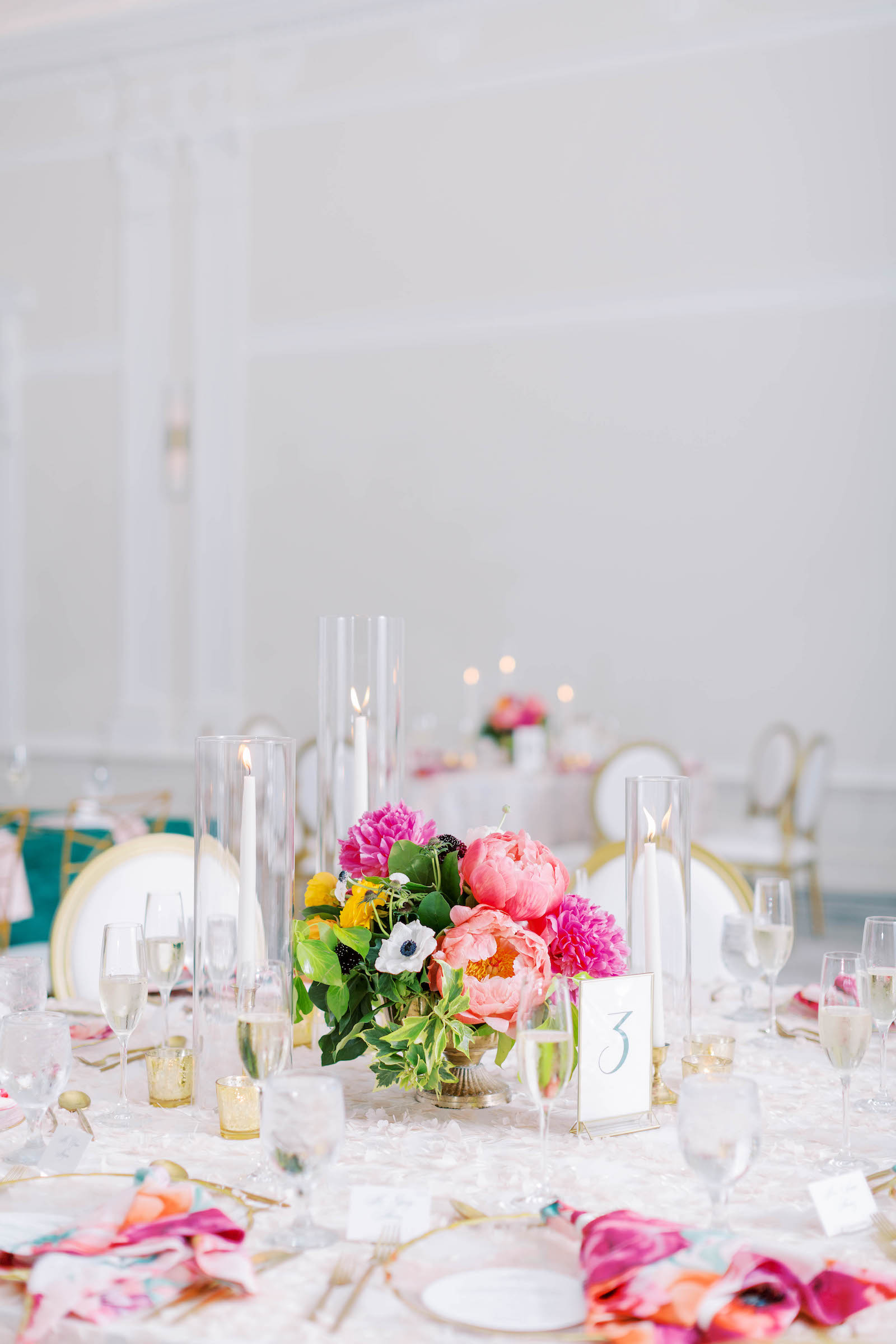 White and Gold Chairs at Wedding Reception with Hot Pink Accents | Tropical Details and Long White Candlesticks with Gold Candle Holders | Floral Pink Centerpieces
