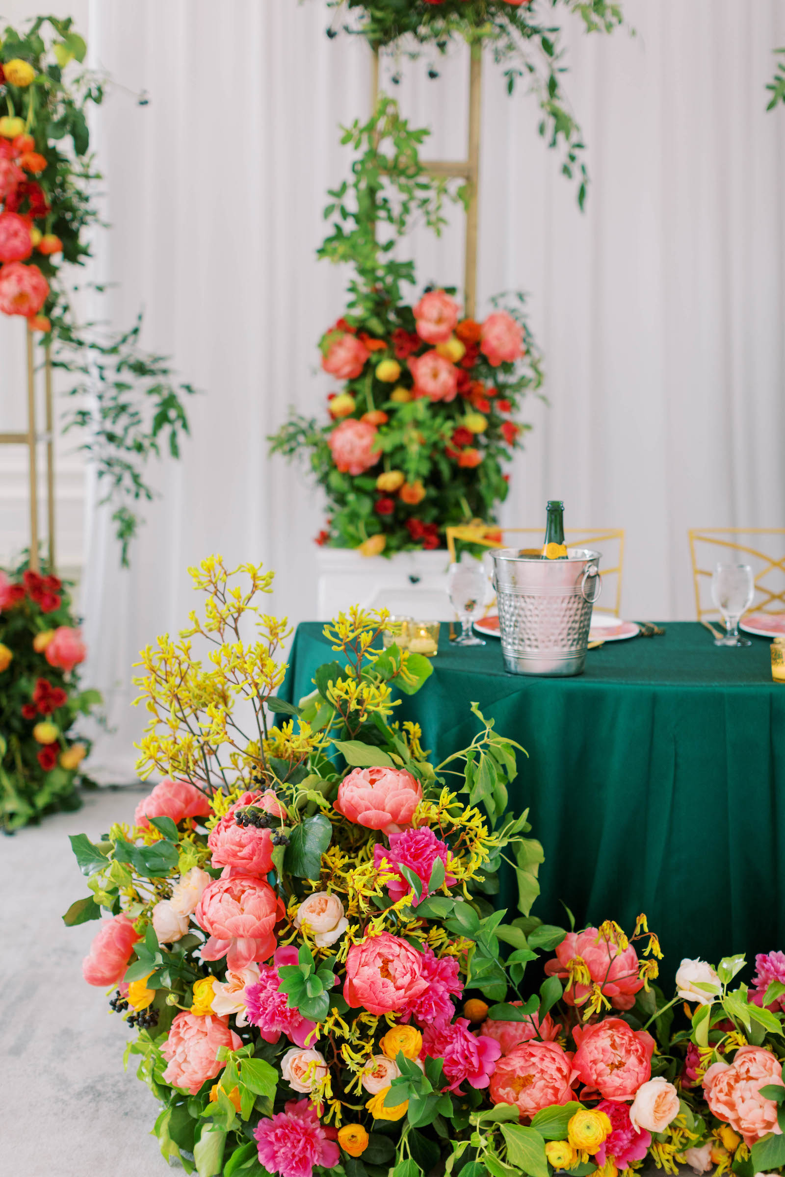 Greenery with Pink and Orange Floral Décor Pieces and Teal Green Sweetheart Table Reception Decor