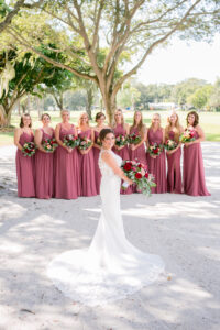 Dusty Rose and Mauve Wedding, Bride Holding Red and Blush Roses and Greenery Floral Bouquet Wearing Lace Wedding Dress, Bridesmaids Wearing Dusty Rose Mix and Match Dresses | Tampa Bay Wedding Photographer Carrie Wildes Photography | Wedding Florist Iza’s Flowers