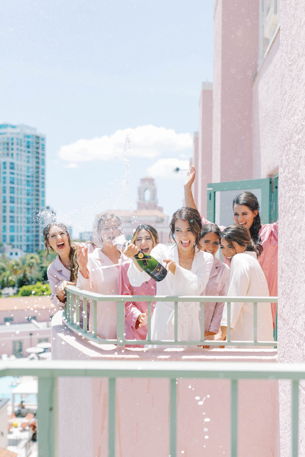 Bride Popping Champagne on Hotel Balcony with Bridesmaids Portrait | St. Petersburg Wedding Venue Vinoy Renaissance