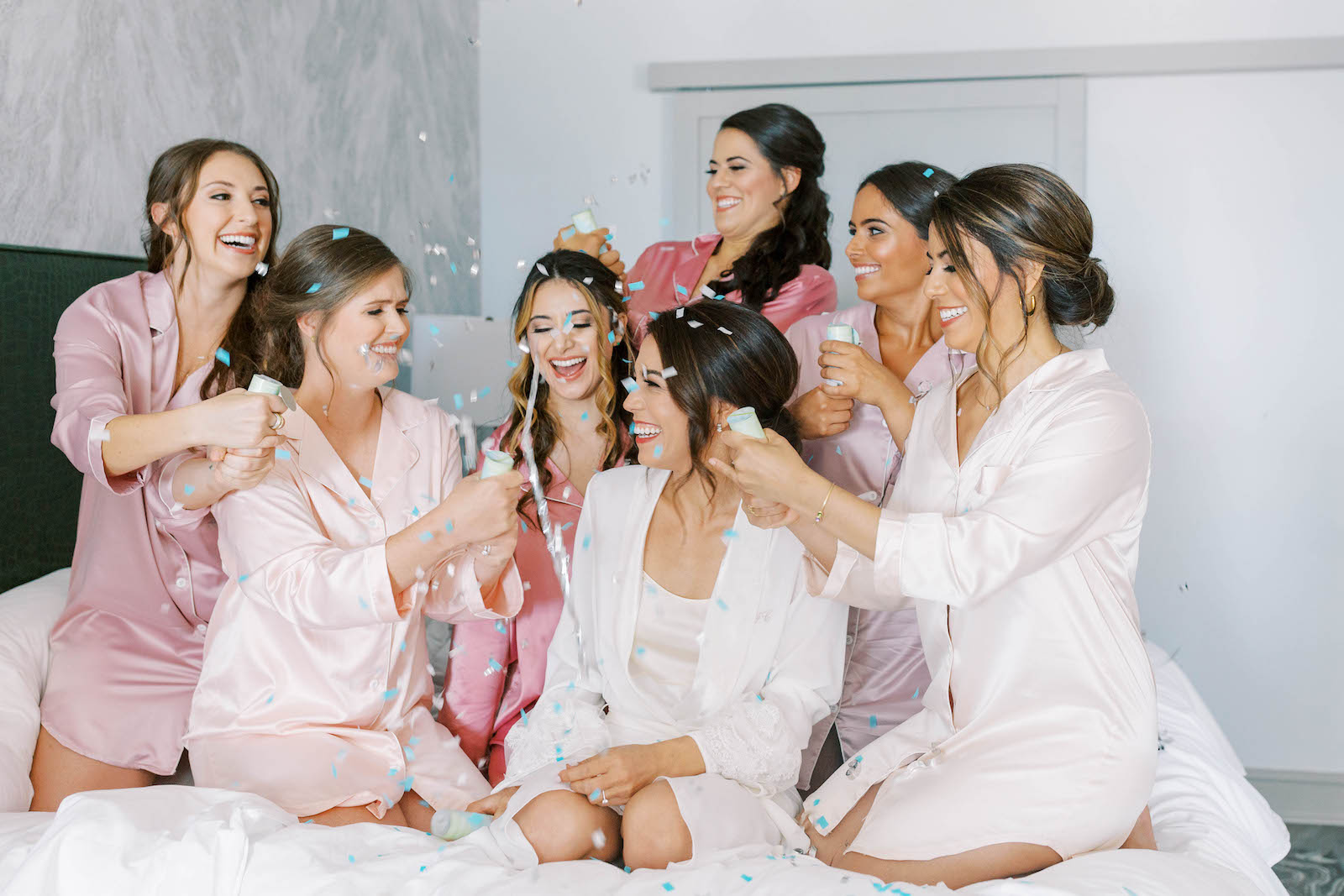 Bride Popping Champagne on Bed in Hotel with Bridesmaids Portrait | St. Petersburg Wedding Venue Vinoy Renaissance
