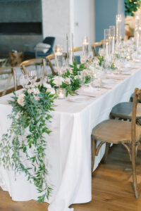 Long Style Table with Wooden Chairs and White Linen | Greenery and Floral Tablescape with Clear Glass Candles | Florida Wedding Planner MDP Event Planning