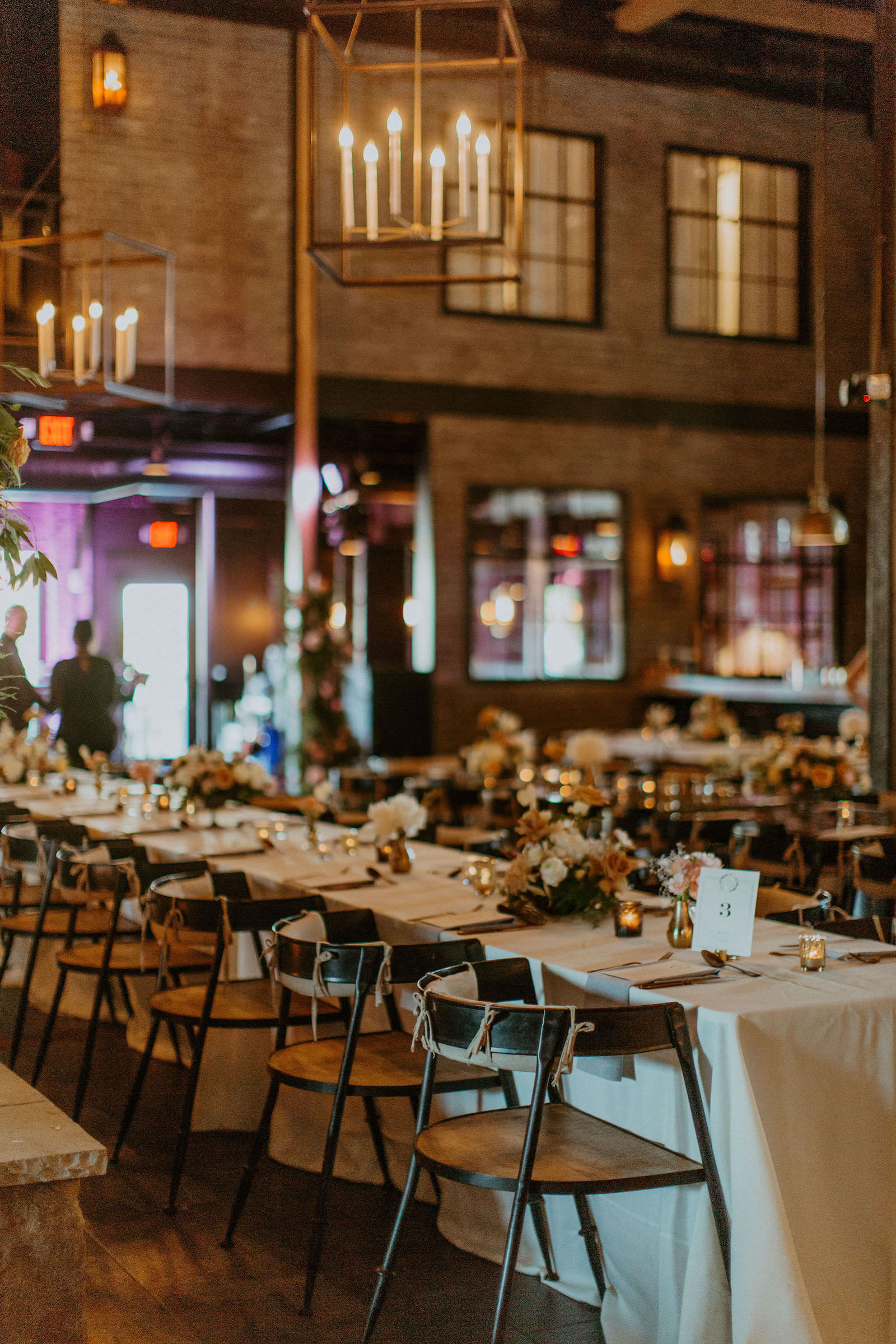 Indoor Industrial Style Wedding Reception with Wooden Chairs and White Long Linen Tablescapes | Urban Stillhouse St. Pete Wedding Reception Venue