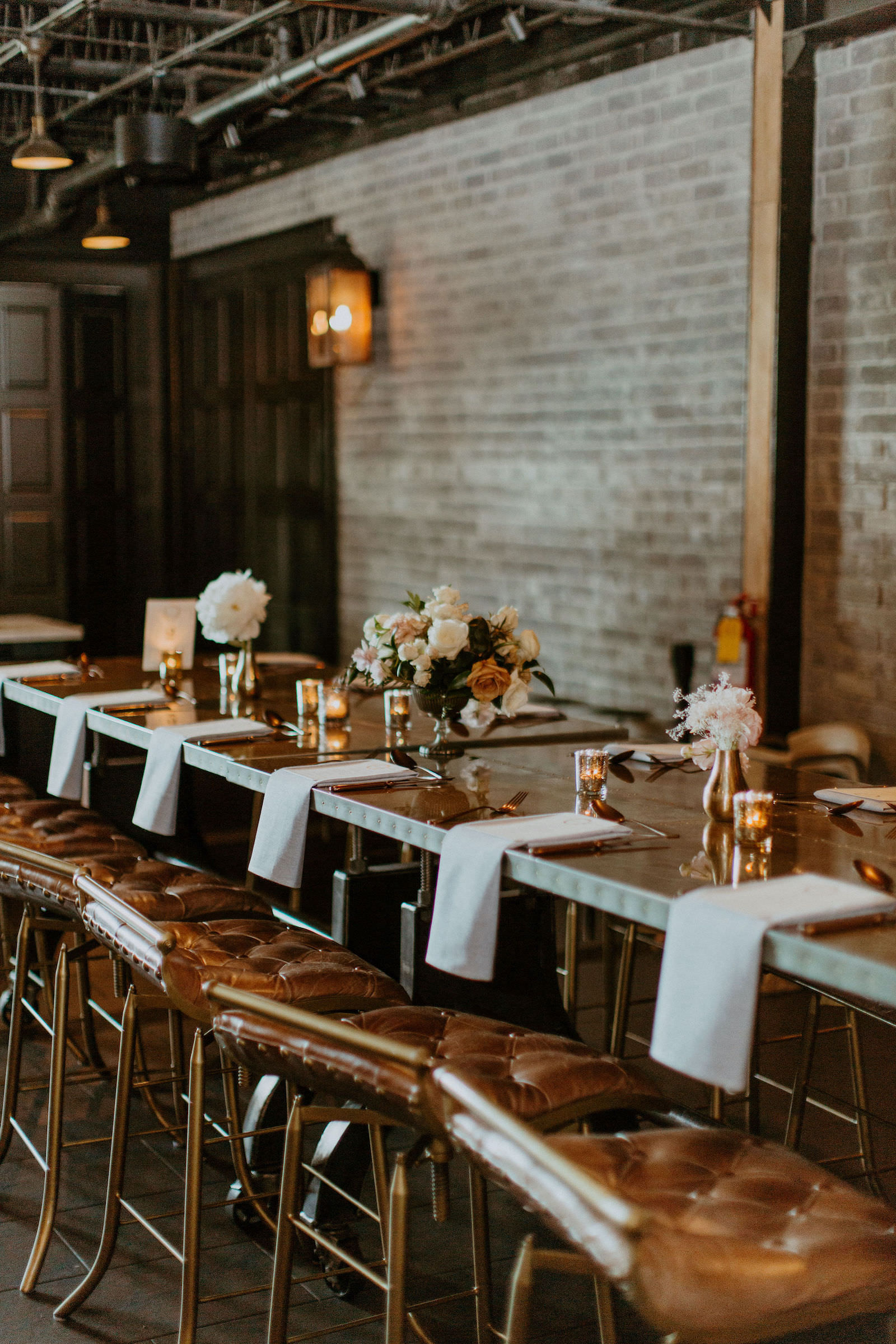 Long Wooden Tables with Brown Benches and Tablescapes with Peach and White Floral Centerpieces | Urban Stillhouse Wedding Reception South Florida