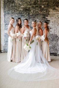 Modern and Timeless Bride with Bridal Party, Bride Wearing Fitted Sequin Open Back Wedding Dress and Full Length Veil, Bridesmaids in Champagne Silk Matching Dresses Holding White Floral Bouquets | Tampa Bay Wedding Photographer Lifelong Photography Studio | Wedding Venue Oxford Exchange