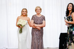 Modern and Timeless Wedding Ceremony, Bride Wearing Fitted Sequin Wedding Dress Holding White Roses Bouquet Walking Down the Aisle with Mom | Tampa Bay Wedding Photographer Lifelong Photography Studio