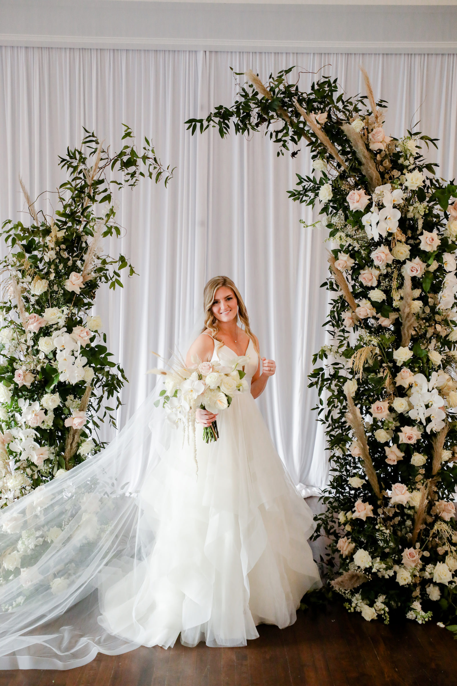 Romantic Blue Coastal Chic Wedding Ceremony Decor, Bride Wearing Tulle Ballgown Wedding Dress and Full Length Veil, Two Piece White Roses, Pampas Grass, Blush Pink Roses, Greenery Floral Two Piece Arch | Tampa Bay Wedding Photographer Lifelong Photography Studio