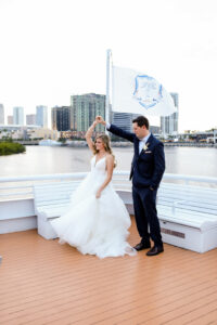 Romantic Blue Coastal Chic Tampa Wedding, Bride Being Twirled by Groom | Tampa Bay Wedding Venue Yacht StarShip | Wedding Photographer Lifelong Photography Studio