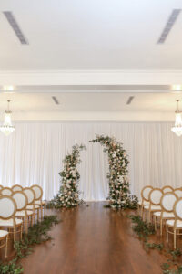 Romantic Indoor Garden Wedding Ceremony with Draped Backdrop, Curved Arch, King Louis Chairs and White and Greenery Florals | South Tampa Venue The Orlo | Kate Ryan Event Rentals | Photographer Lifelong Photography Studio
