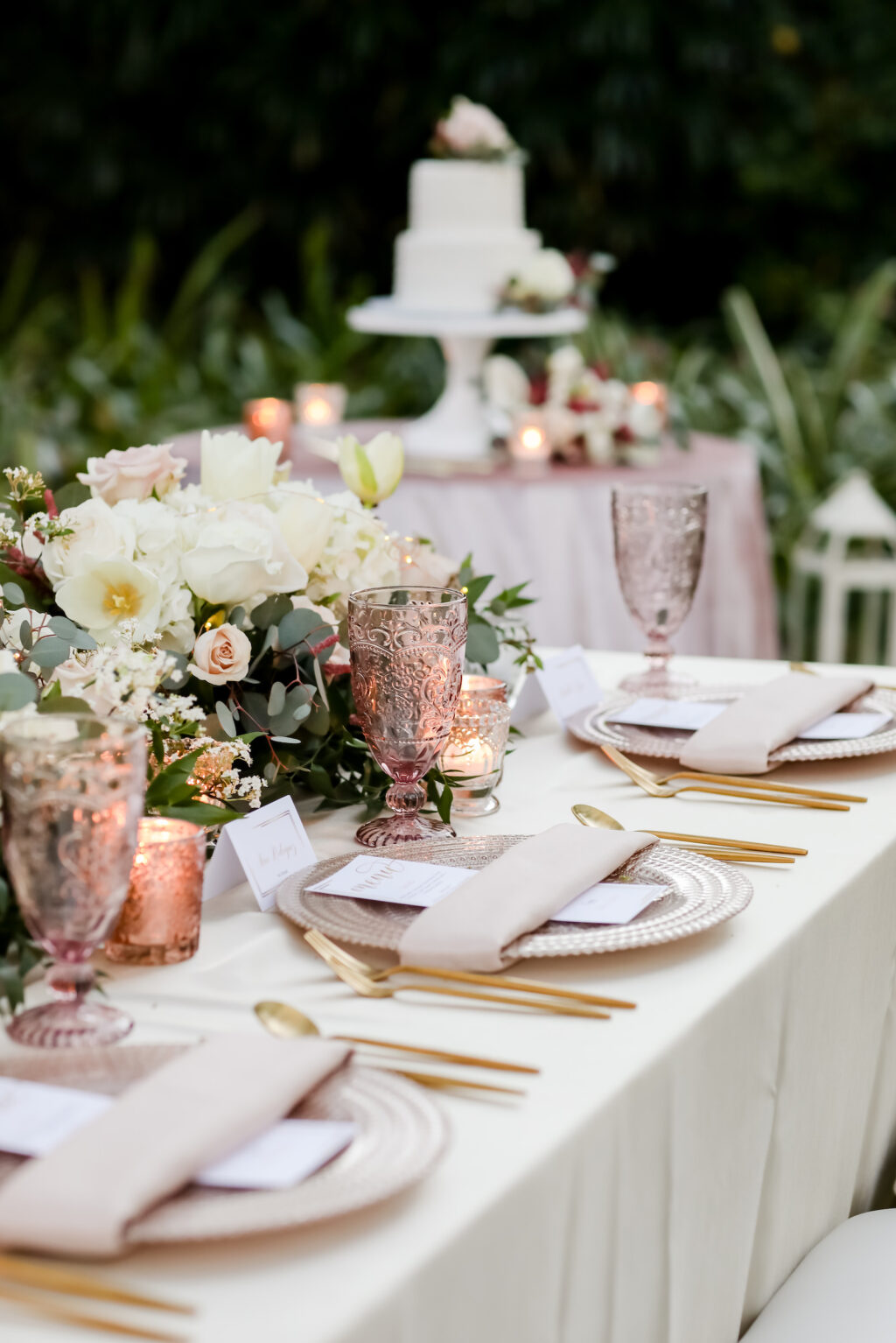 Romantic Pink Wedding Reception Decor, Long Table with Ivory Linen, Gold Silverware, Vintage Pink Glassware, White Hydrangeas, Greenery Eucalyptus, and Pink Floral Garland | Tampa Bay Wedding Photographer Lifelong Photography Studio | Wedding Planner Special Moments Event Planning | Wedding Rentals Kate Ryan Event Rentals |
