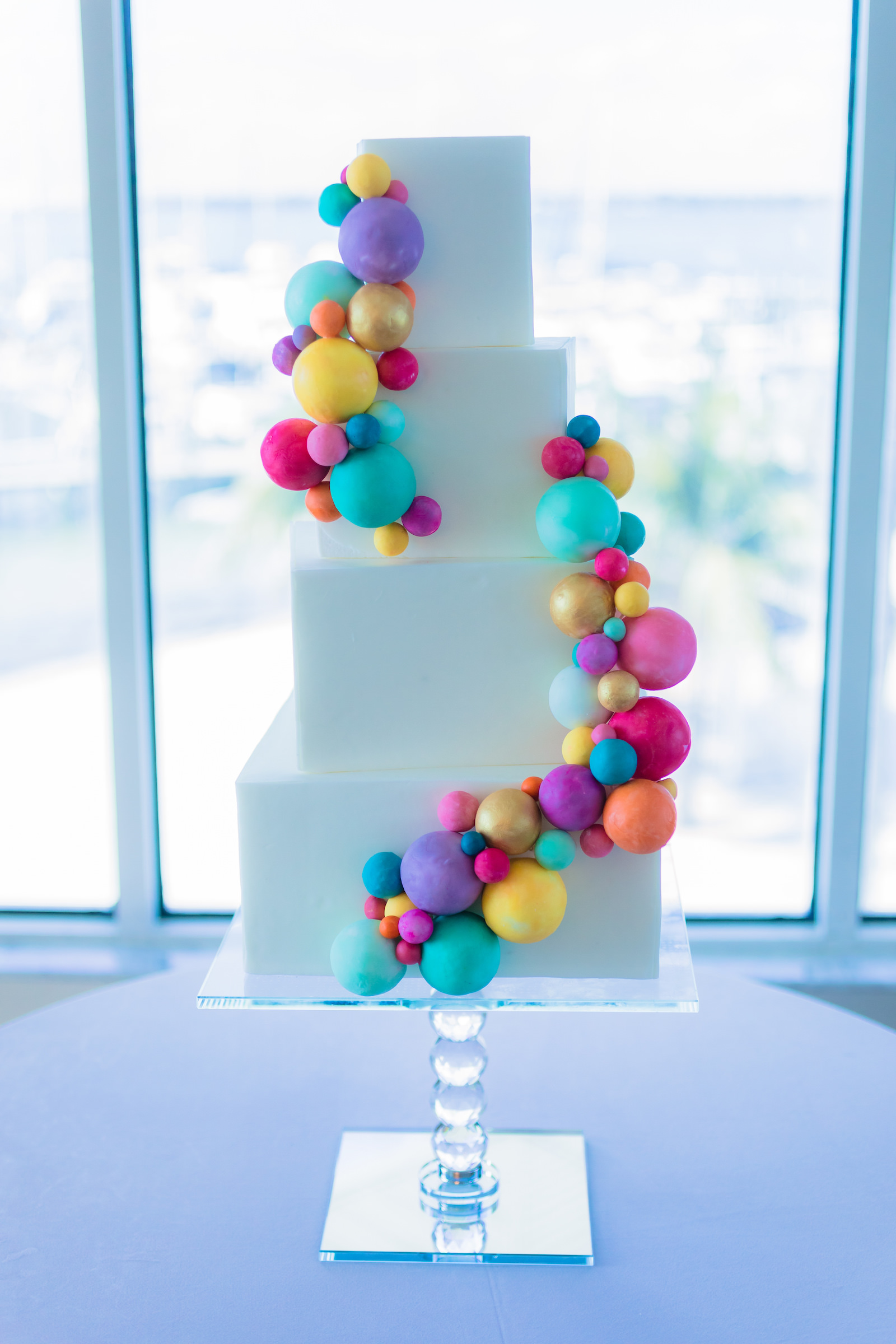 Four Tier White Wedding Cake with Colorful Round Detail Swirling Up the Cake | Wilder Mind Events | Tampa Bay Cake Company