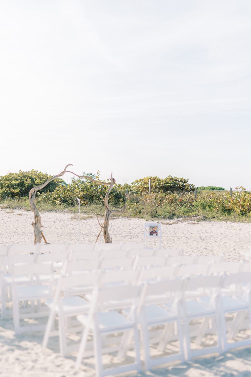 Beach Wedding with Natural Wood Ceremony Arch and White Chairs | St. Pete Wedding Ceremony Postcard Inn On the Beach