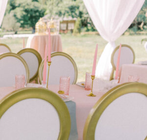 Garden Whimsical Wedding Decor, Table with Tall Pink Candles in Gold Candlesticks, Pink Vintage Glassware, Louis Chairs | Tampa Wedding Venue Mill Pond Estate | Kate Ryan Event Rentals