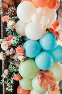 Whimsical Orange, Yellow, and Blue Balloon Arch and Floral Décor for an Industrial Wedding Ceremony