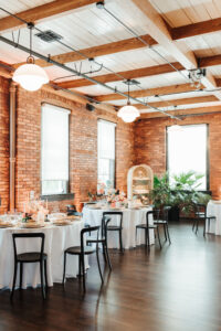 Industrial Indoor Wedding Reception White Linens, Black Metal Chairs, and Red Brick Walls | JC Newman Cigar Factory Tampa Florida Wedding Venue