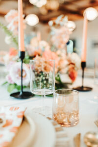 Unique Wine Glasses on Wedding Reception Tablescape with Tall Peach Pastel Taper Candles in Black Candle Holders