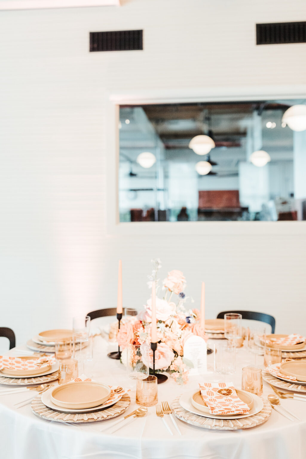 White Linen and Black Metal Chair with Peach Pink Floral Centerpieces in Black Candle Holders