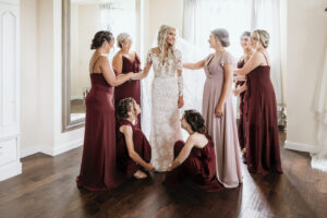 Bride in Illusion Long Sleeve All Lace Wedding Dress Getting Ready with Bridesmaids in Blush and Burgundy Wedding Portrait