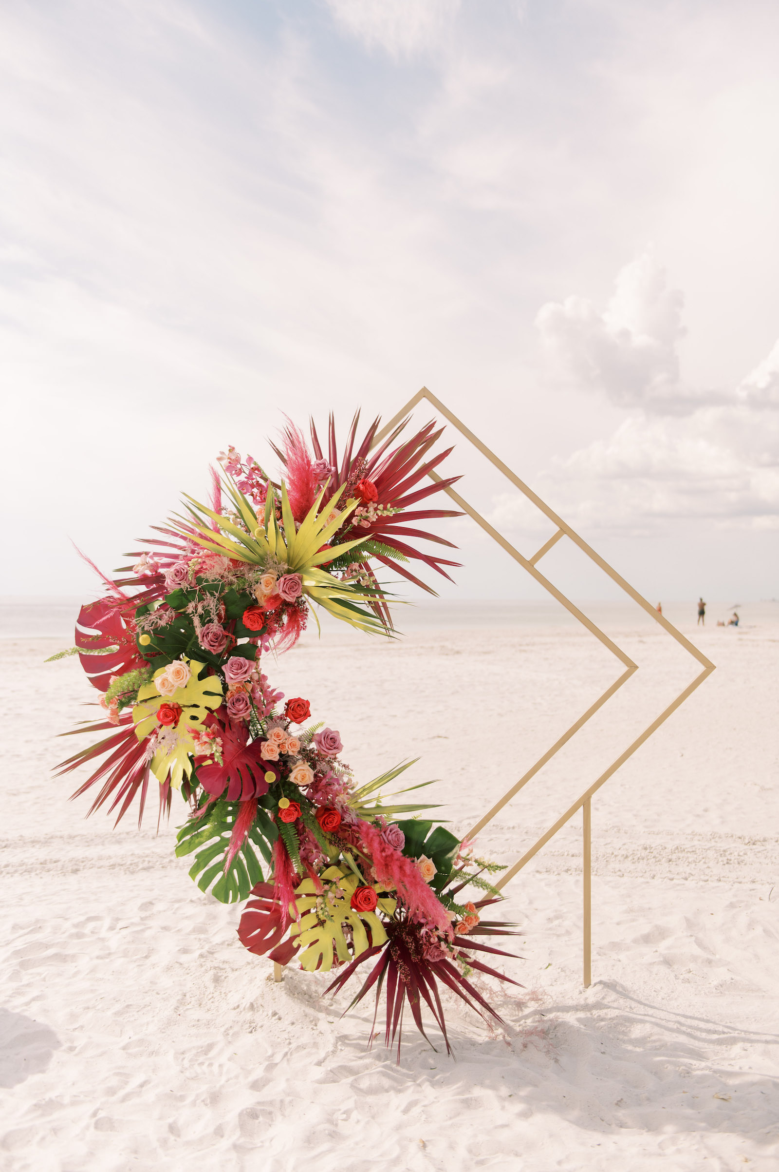 Vibrant Boho Beach Wedding Ceremony Decor, Geometric Gold Diamond Arch with Hot Pink and Vibrant Green Monstera Leaves, Palm Fronds, Red and Pink Roses Floral Arrangement