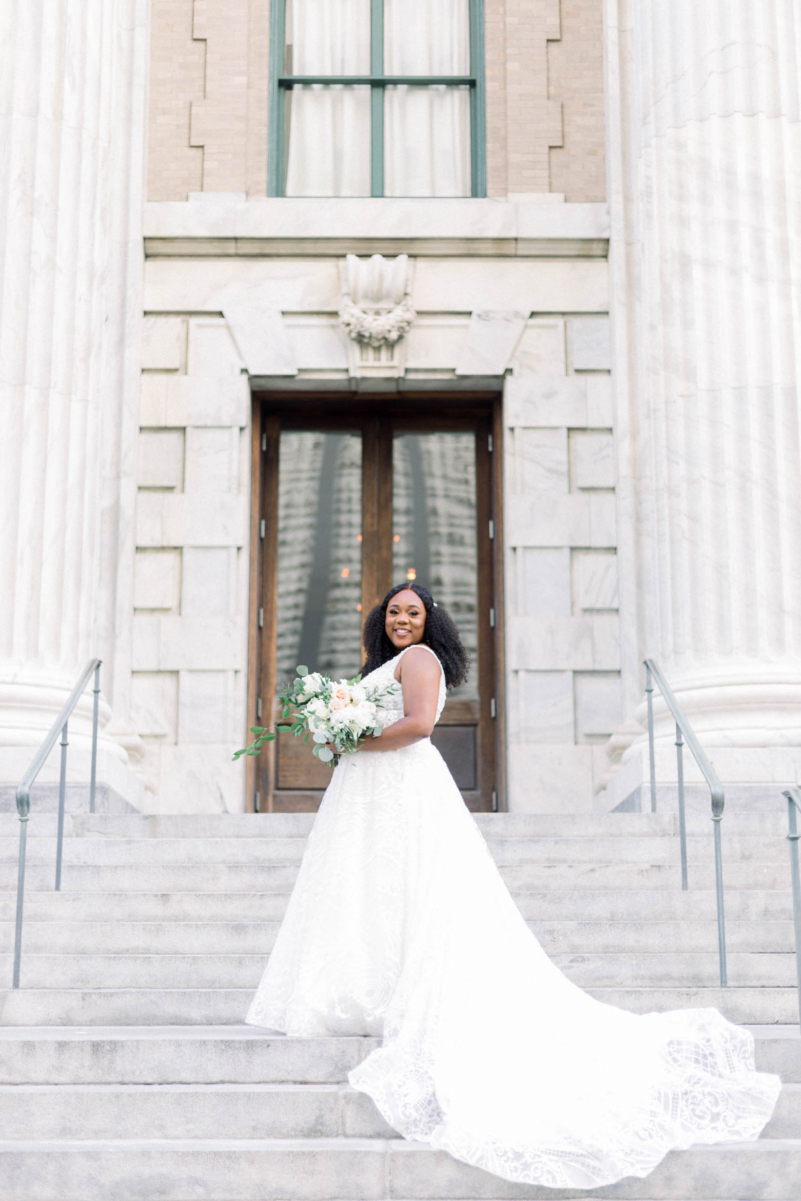 Bride on Steps in Long Train Ballgown and White Floral Bouquet with Greenery Wedding Portrait
