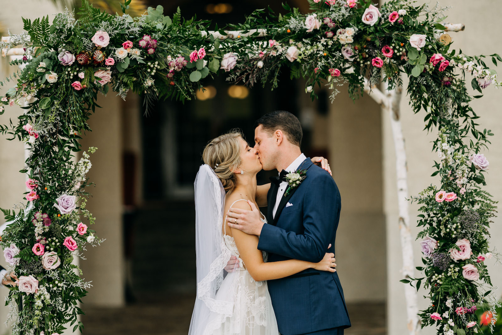 Florida Bride and Groom Exchanging Wedding Vows During Ceremony at Dunedin Wedding Venue The Fenway Hotel, Lush Birch Frame with Greenery, Pink and Purple Roses Flowers | Tampa Bay Wedding Photographer Amber McWhorter Photography | Wedding Florist Leaf It To Us