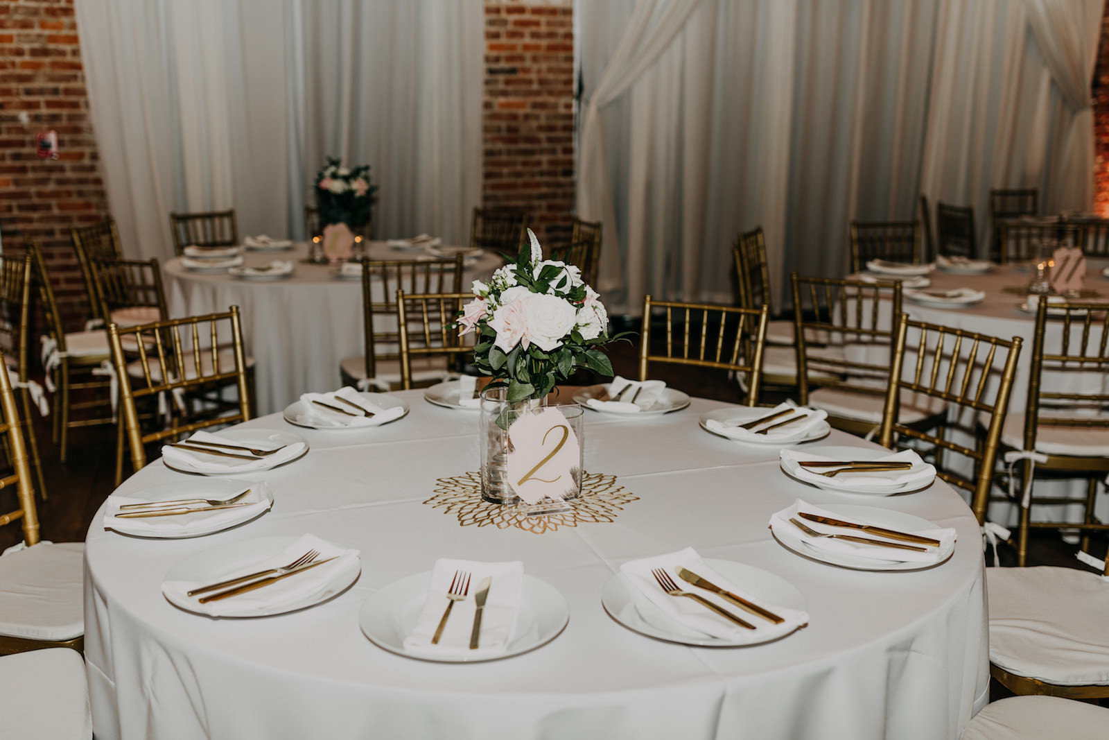 White Round Table Linens and Gold Flatware with Floral and Greenery Centerpieces | St. Petersburg Wedding Venue Nova 535
