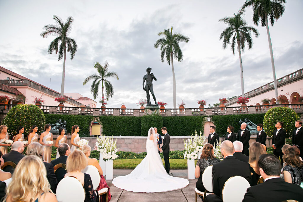 Bride and Groom Exchanging Wedding Vows, Luxurious Modern Outdoor Courtyard Wedding Ceremony Decor, White and Gold Wedding Chairs | Tampa Bay Wedding Photographer | Sarasota Wedding Venue Ringling Museum