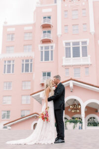 Vibrant Boho Wedding, Bride and Groom Kissing Outside St. Petersburg Historic Pink Palace The Don CeSar