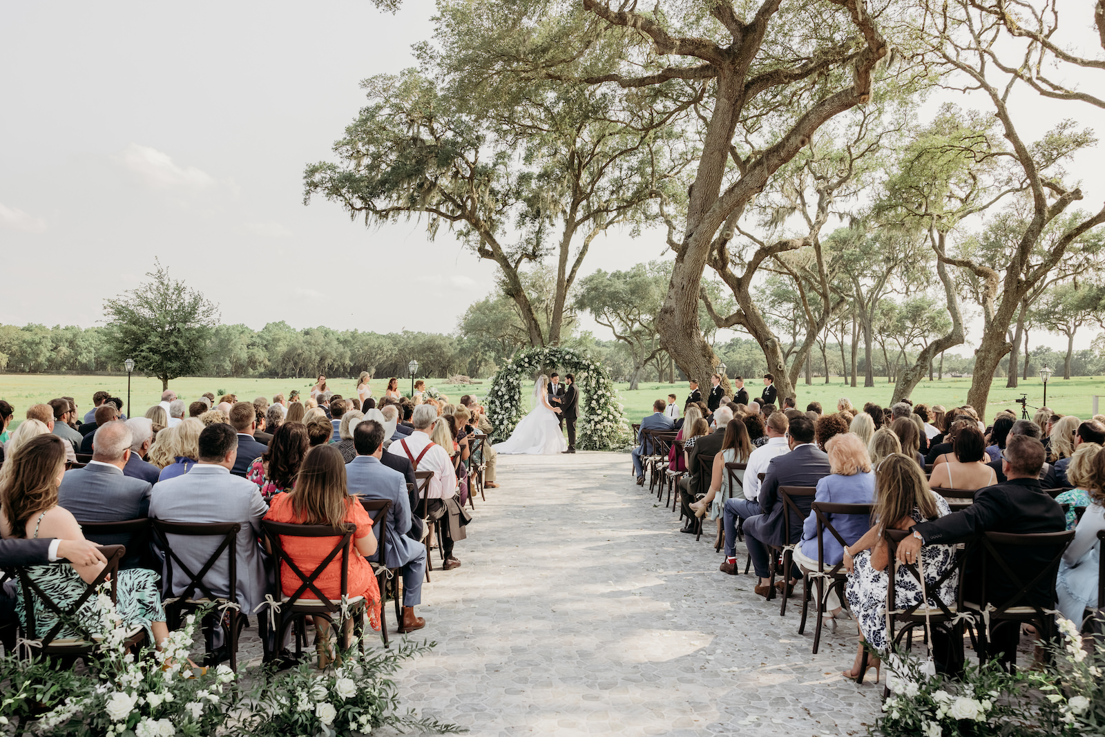 Bride and Groom Exchanging Wedding Vows, Classic Outdoor Wedding Ceremony Decor, Greenery and White Floral Arch | Tampa Bay Outdoor Wedding Venue Simpson Lakes